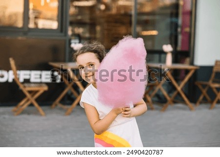 Similar – Image, Stock Photo Cheerful girl eating cotton candy on street