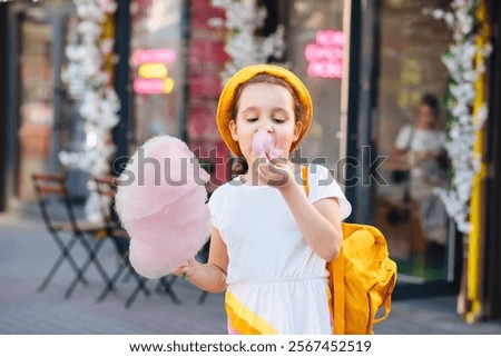 Similar – Image, Stock Photo Cheerful girl eating cotton candy on street