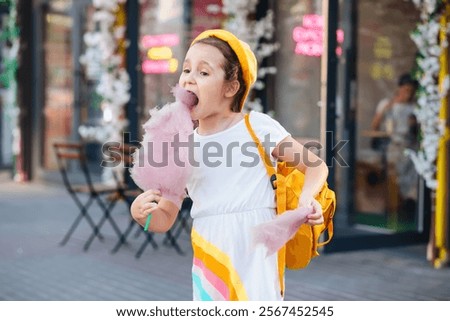 Similar – Image, Stock Photo Cheerful girl eating cotton candy on street