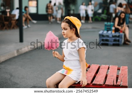 Similar – Image, Stock Photo Cheerful girl eating cotton candy on street