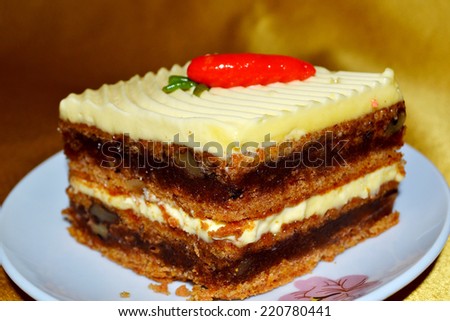 Delicious slice of cake with cream and decoration in the form of carrots.