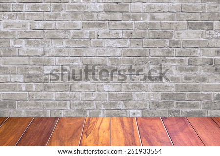 Grungy textured grey brick and stone wall with warm brown wooden floor inside old neglected and deserted interior, masonry and carpentry brickwork concept