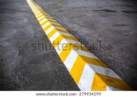 A yellow stripe speed ramp on concrete road.
