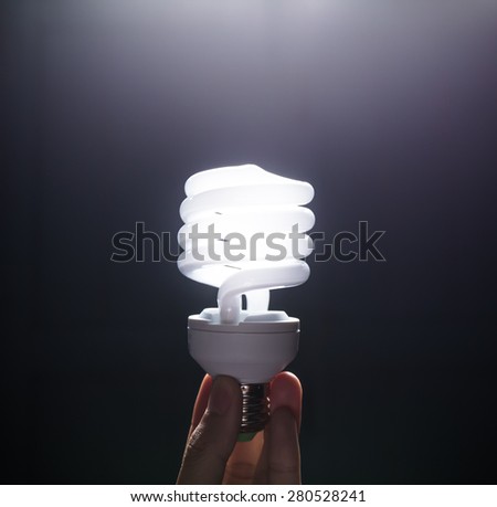 Energy saving fluorescent light bulb, isolated black background