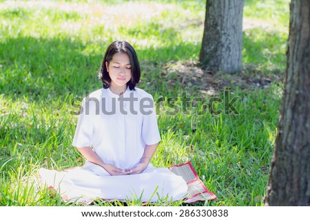 Girl meditation in the park. Peace position of girl meditate on grass in park. Meditation affects the control of body and mind. Helps the body relax from work or fatigue as well.