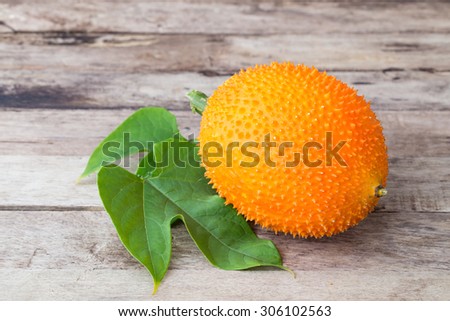 Gac,Baby Jackfruit Spiny Bitter Gourd, Sweet Gourd.A Southeast Asian fruit isolate on wooden table background.
