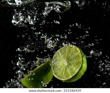 Lime falling in water, lime in the fall, collision with lime water (on a black background)