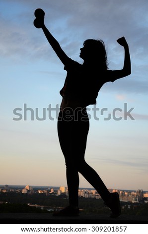 silhouette of girl athletes (with dumbbells in hand) athletic girl at sunrise