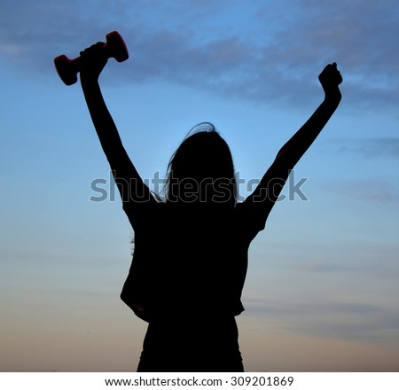 silhouette of girl athletes (with dumbbells in hand) athletic girl at sunrise