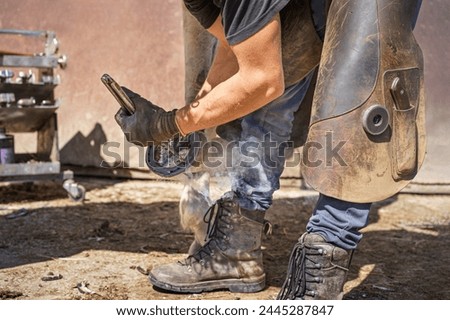 Similar – Image, Stock Photo Blacksmith taking horseshoe from furnace