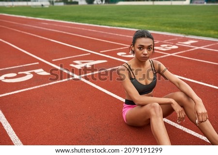 Similar – Image, Stock Photo Serious black sportswoman sitting on stone border in city