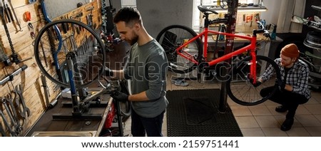 Similar – Foto Bild Konzentrierter Mann repariert Fahrrad in Garage