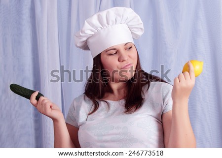 Portrait of female cook in front of a difficult choice - lemon or ourets. Menu selection. Cooking, food