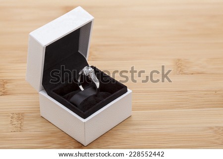 Diamond ring in white box on a wooden background
