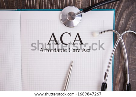 Notebook page with text ACA Affordable Care Act, on a table with a stethoscope and pen, medical concept. Imagine de stoc © 