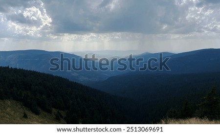 Similar – Image, Stock Photo Thunderstorm over the hill . Only a small bright glow over the blue black rain clouds, the rainforest.  As if the world wanted to end.