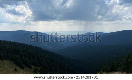 Similar – Image, Stock Photo Thunderstorm over the hill . Only a small bright glow over the blue black rain clouds, the rainforest.  As if the world wanted to end.