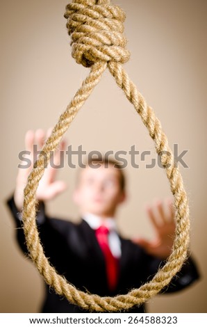 Scared man is suit with hanging noose