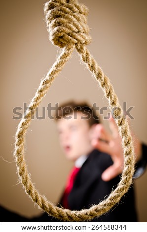 Scared man is suit with hanging noose