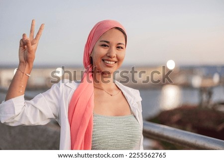 Similar – Image, Stock Photo Woman with pink scarf for cancer looking at the sea in bikini from the beach