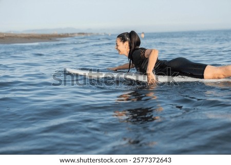 Similar – Image, Stock Photo Serene woman on surfboard in sea