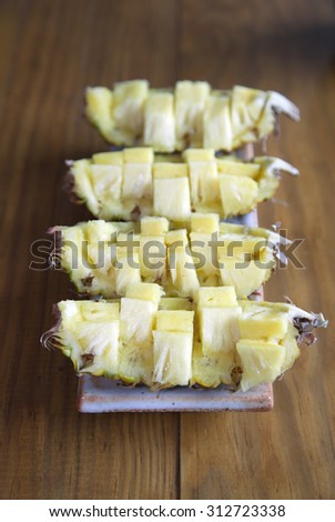 pineapple chunks in white bowl on wood table