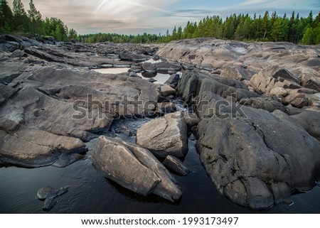 Stone river bed. Rocky shores covered with coniferous forest. Water, finding narrow places among the stones, seeps, flowing into small pools.  Stok fotoğraf © 