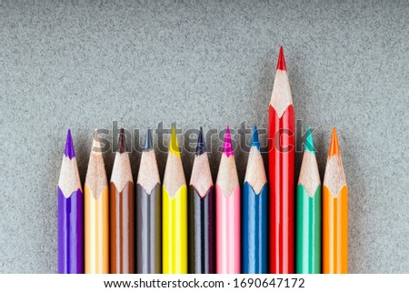 One red pencil stood out from a row of colored pencils. Leadership, uniqueness, think differently, team success in business. Photo stock © 