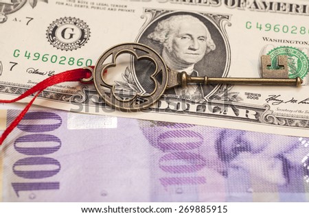 Key To Success With Red Bow on One American dollars and 1000 Swiss franc currency