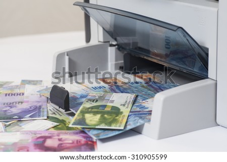 Printer printing fake Swiss francs, currency of switzerland on white background