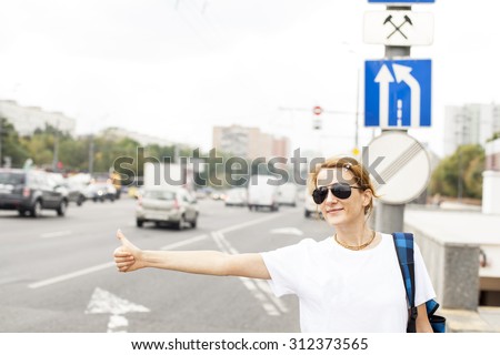 woman standing in the street, calling taxi