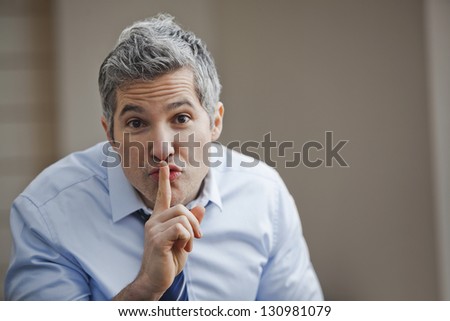 Portrait of a businessman with his finger on lips