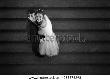 Couple in love is embracing on the stairs and looks up
