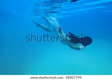 Girl under the water with a flower