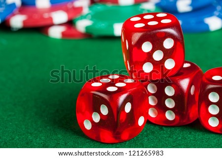 Group of chips and dices on the green cloth.