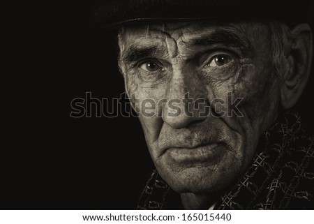Monochrome portrait of an elderly man on black background