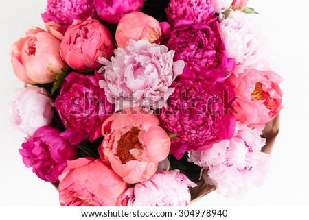 Close-up rich bunch of peonies and tea roses on white background top view