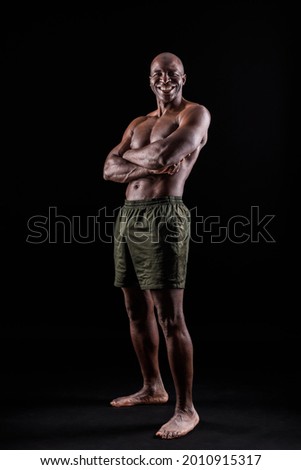 African American man standing in shorts with arms crossed in a black background Stock foto © 