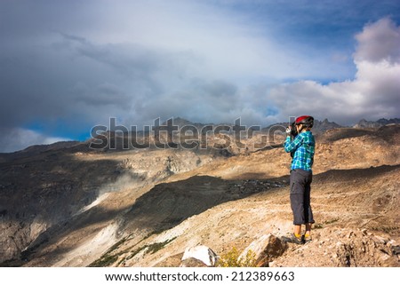 Woman bicyclist taking photo of fantastic himalayas landscape. Jammu and Kashmir State, North India
