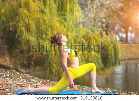 Young woman doing yoga in autumn yellow park