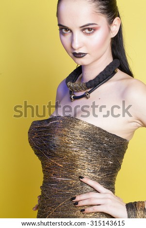 beautiful brunette girl in the short gold dress