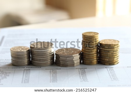 stacks of gold coin and silver coin tower shape on business investment finance report blue paper