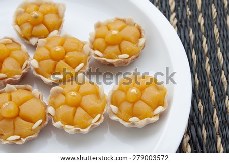 Thai sweet dessert in shape like golden crown with real gold tip on white dish