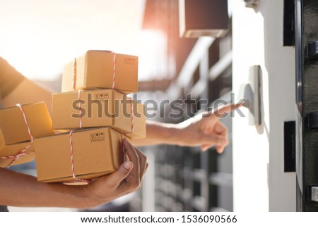 Delivery man holding parcel boxes and ring the doorbell on the customer door in the morning background, transportation and logistics, delivery service concept.