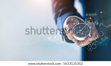 Businessman holding a navigation compass in hand and define marketing direction and analysis growth sale data with search customer global network, Abstract business. 