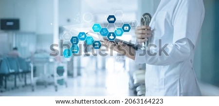 Healthcare business and Medical examination, Doctor use tablet and icon medical with analyzing data and growth chart on hospital background, Health Insurance, Medical business and technology concept.