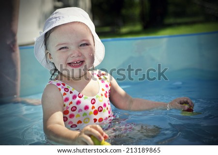 Small girl playing in swimming pool