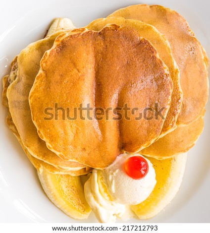 Pancake, banana, and butter as breakfast