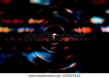 Dark abstract background of spin circle radial blur of a brick wall in multicolor