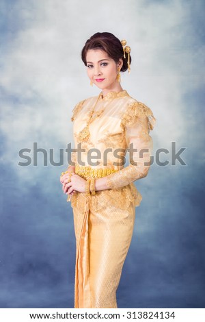 portrait beautiful thai woman in vintage thai traditional costume,gold color dress